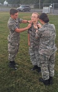 Photo submitted Cadet 1st Lieutenant Ryan Hebert, left, and Cadet Captain Paige Rice, right, promote Chloe Birt, center. Birt was the first cadet to join the squadron, and the first cadet to complete the achievements needed to promote to Cadet Airman.