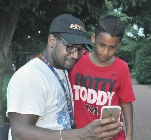 Robin Hart/robin.hart@amnews.com Jeffrey Guest with his son, Braylon, now 9, as they search for Pokémon last year. Braylon has only ever known his dad in a wheelchair, but Jeffrey hopes a procedure could change that.