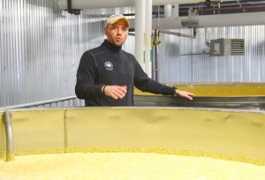 tour guide Jerod Smith stands between two vats where bourbon is fermenting.