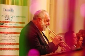 Seen through green and purple streamers, globally acclaimed trumpeter Vincent DiMartino performs early in the evening.