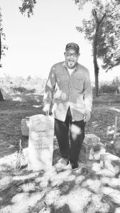 James Hunn of Danville stands by a military tombstone of his great-great-grandfather Jordan Wallace, a corporal in the Civil War. Wallace is buried in the Shelby City African American Cemetery.